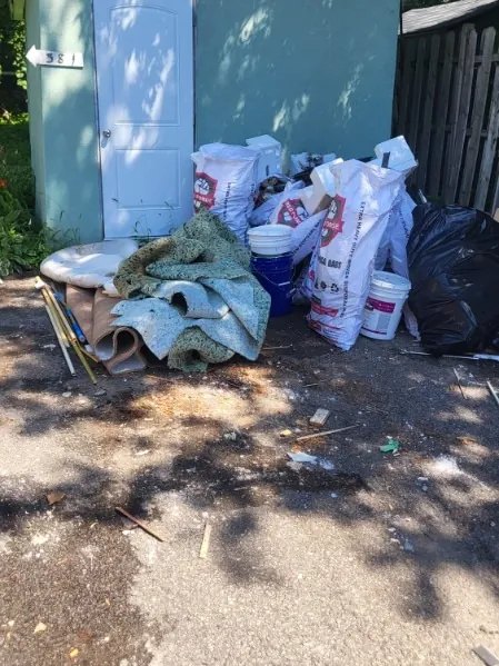 Avant: sacs, seaux et débris devant le cabanon